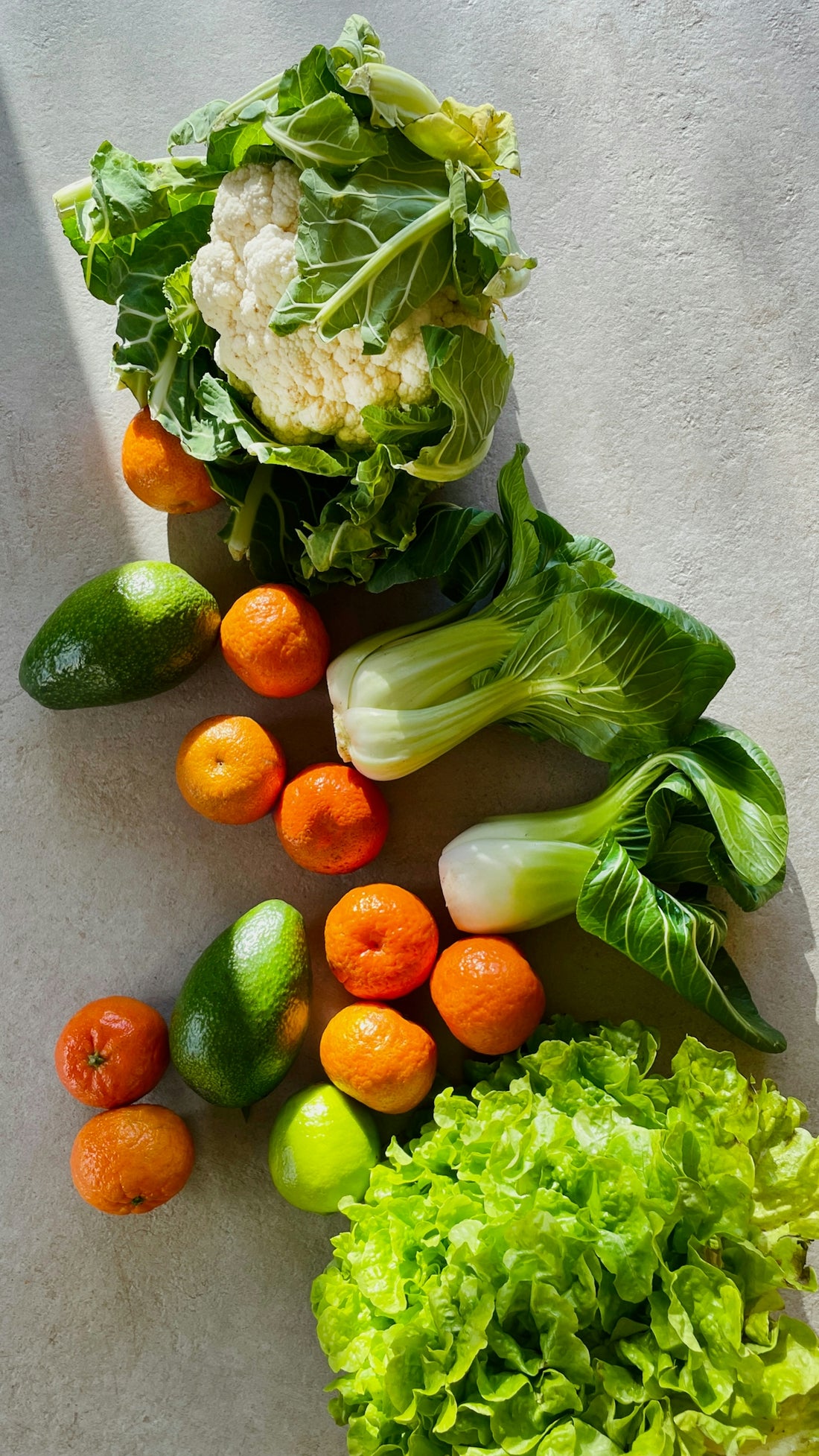 a table topped with lettuce, carrots and other vegetables