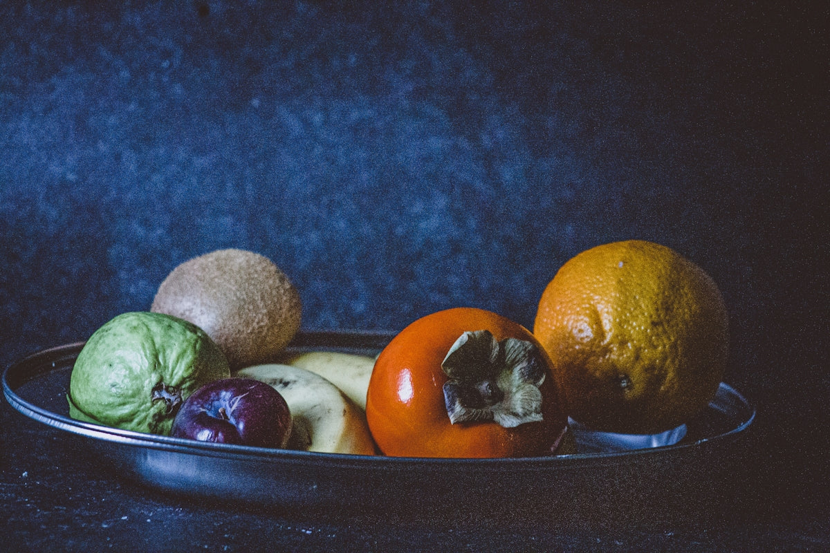 orange fruit on black ceramic bowl
