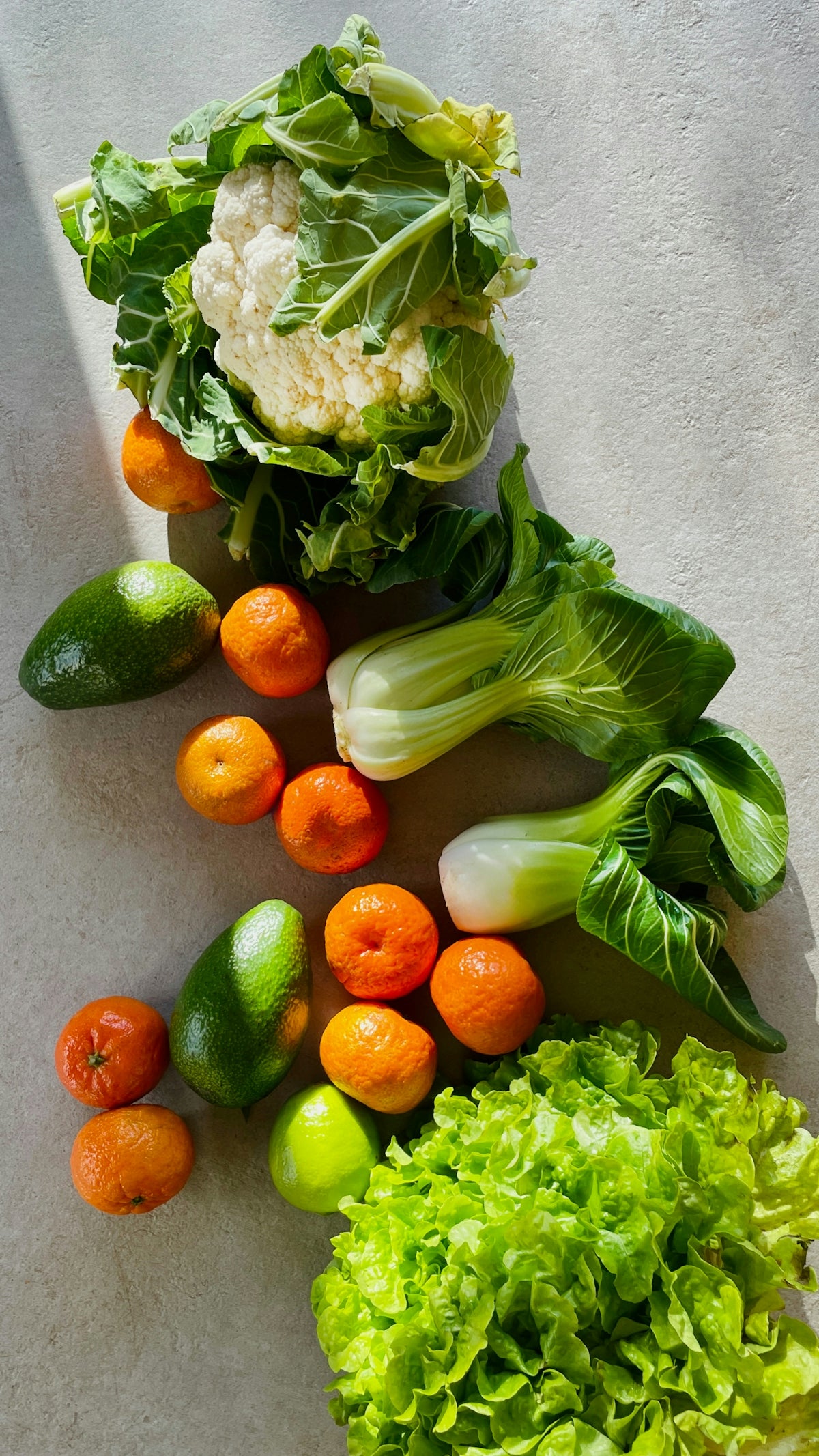 a table topped with lettuce, carrots and other vegetables