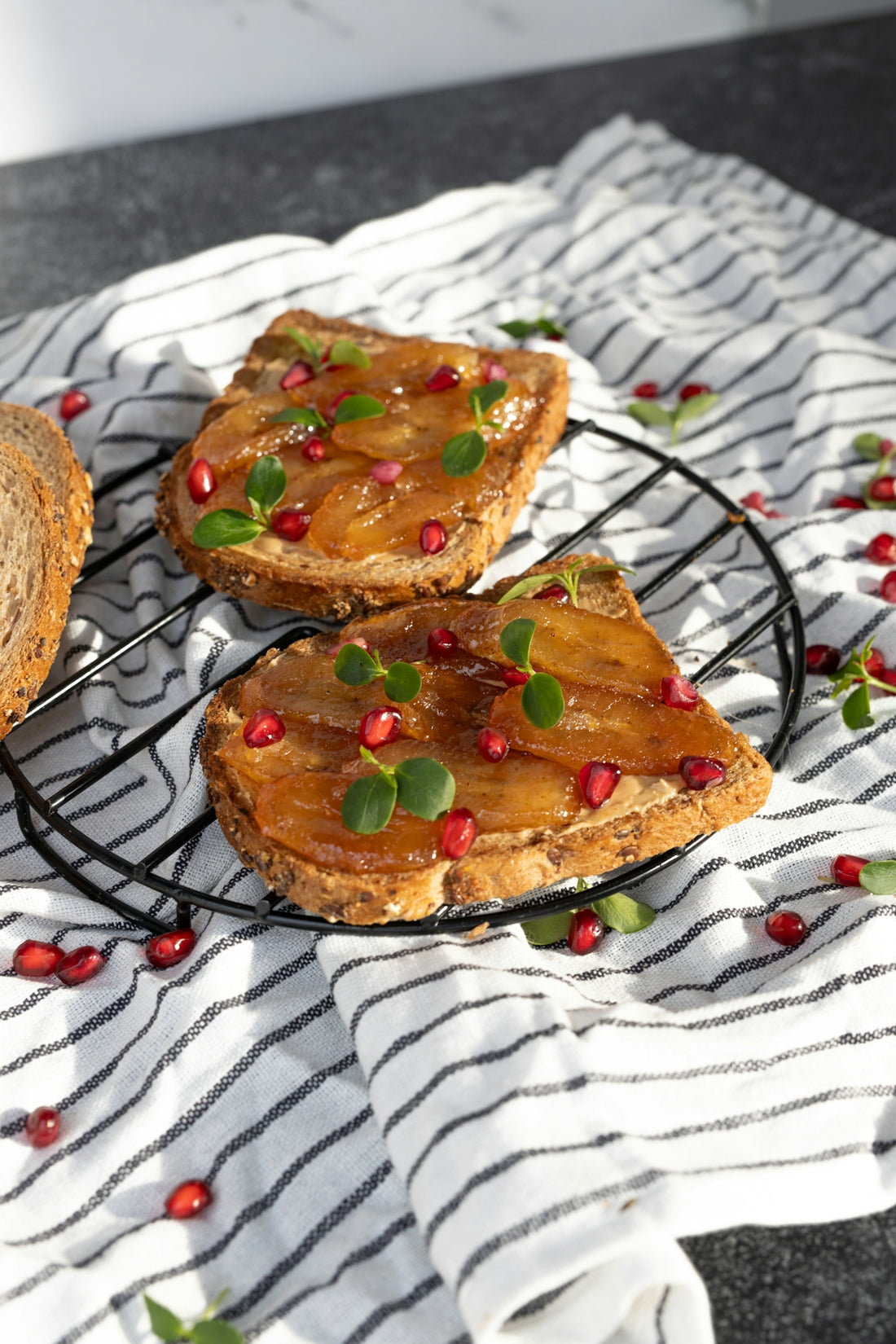 three pieces of bread with pomegranates on a wire rack