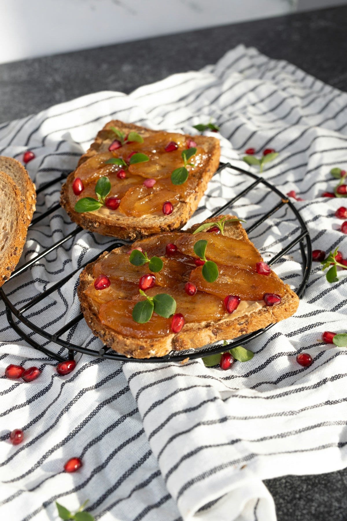 three pieces of bread with pomegranates on a wire rack