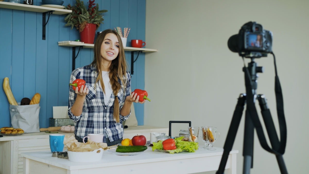 Woman filming cooking tutorial with fresh vegetables