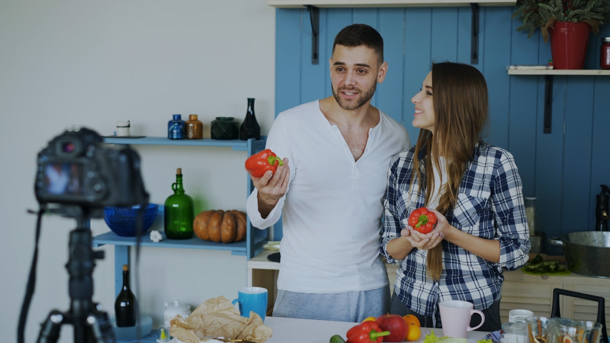 Couple filming a cooking show in the kitchen.